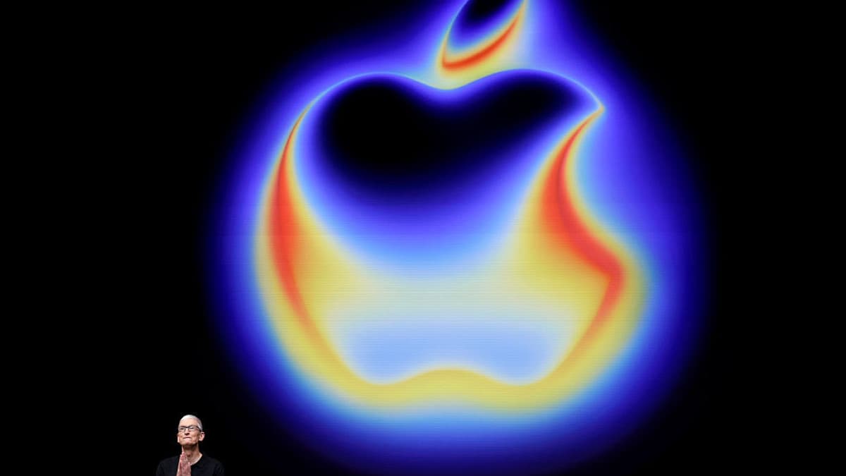 Apple chief executive Tim Cook standing in front of a glowing Apple logo