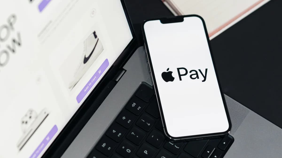 iPhone held near a contactless payment terminal to pay with Apple Pay